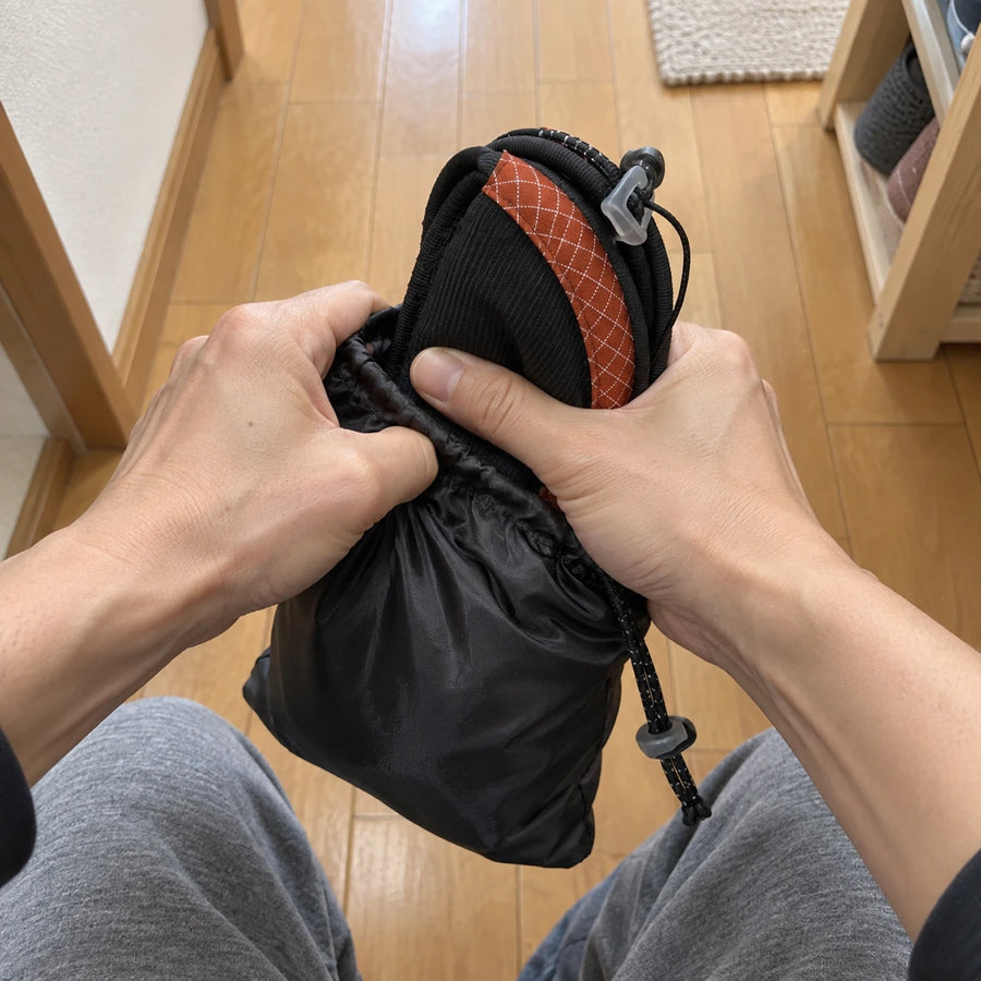 丸めたスリッパを巾着に入れる様子
