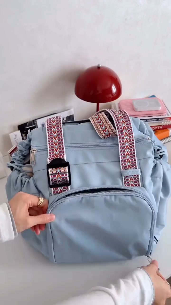 口を閉じたバッグの前面ポケットを開ける様子