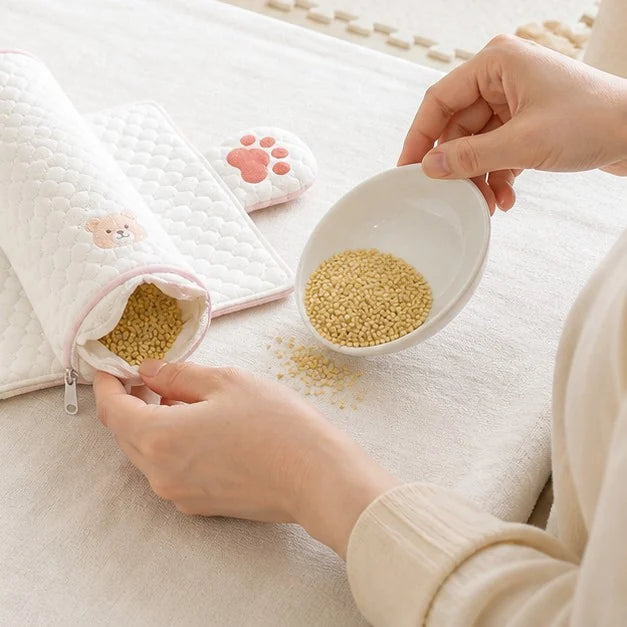 開いたふくらみに、器から雑穀のつぶを入れているところ