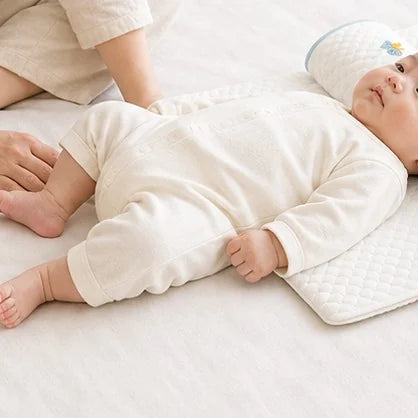 ネムポケに頭をあずけて横になっている赤ちゃん